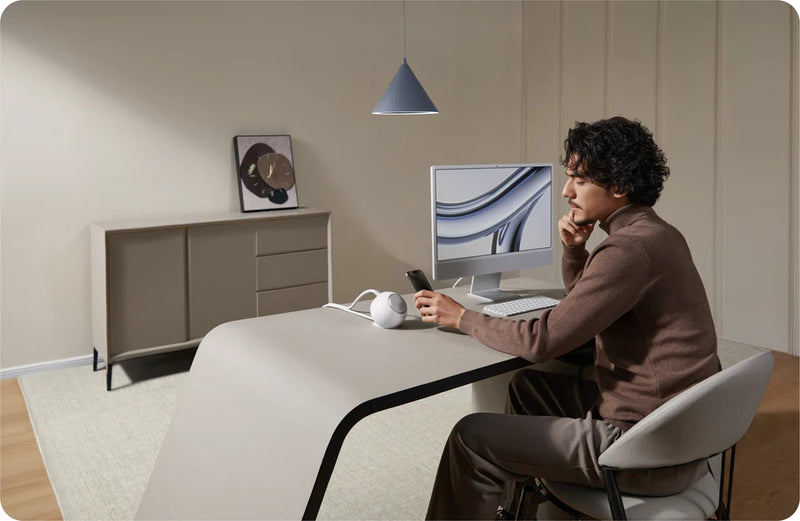 Person sitting at a desk using a computer in a modern office setting